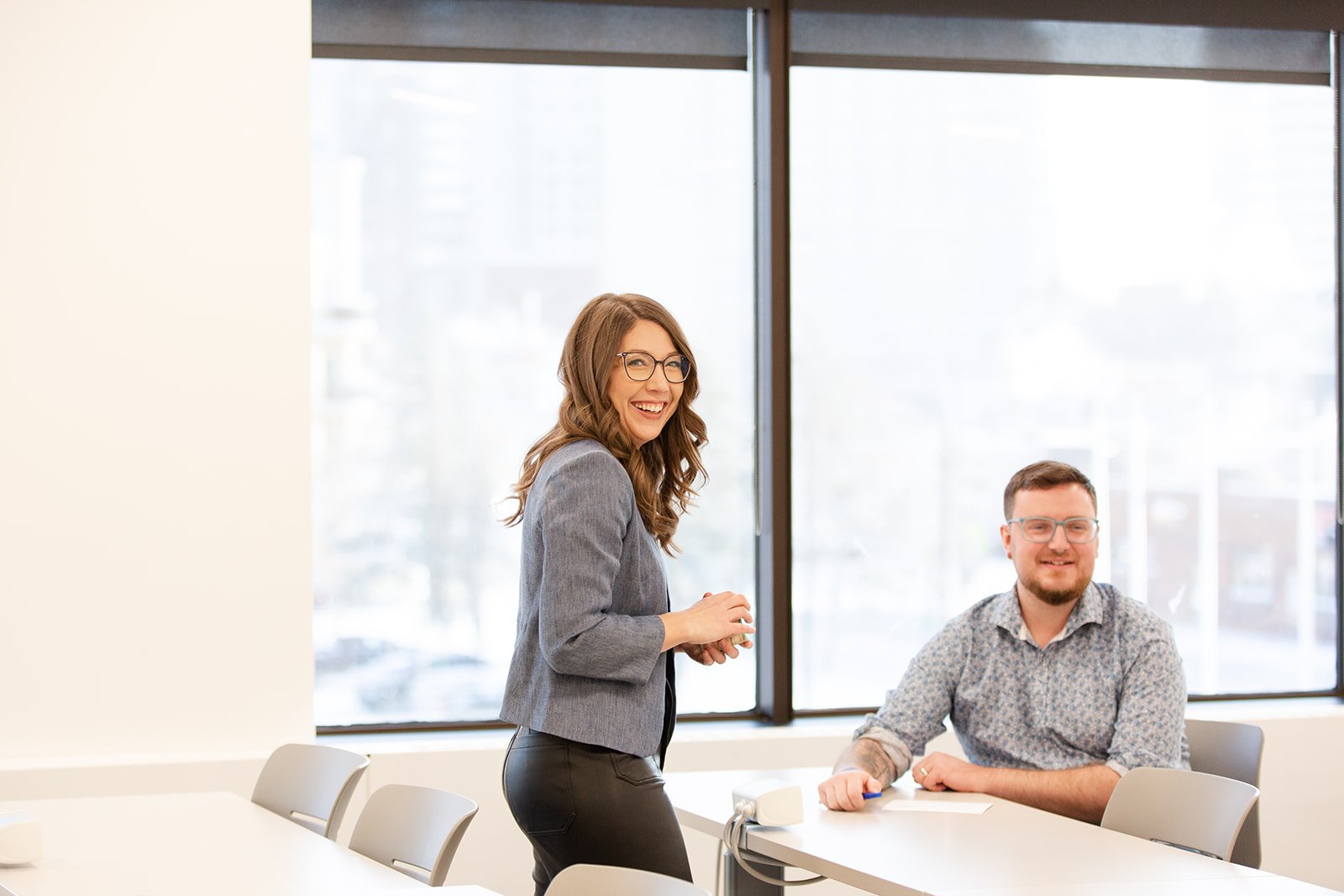 Lindsay laughing with a workshop participant in a bright meeting room.